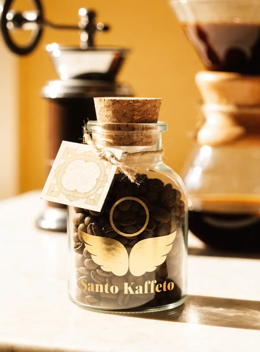 Frasco de vidrio con tapa de corcho lleno de café y carta amarrada al cuello